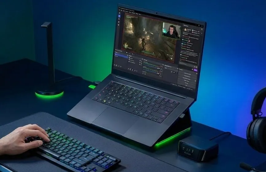 Best Laptop for Streaming in 2026 – Our Top Picks 35 Razer Blade 14 laptop shown on a desk running a game and live streaming software with RGB keyboard lighting