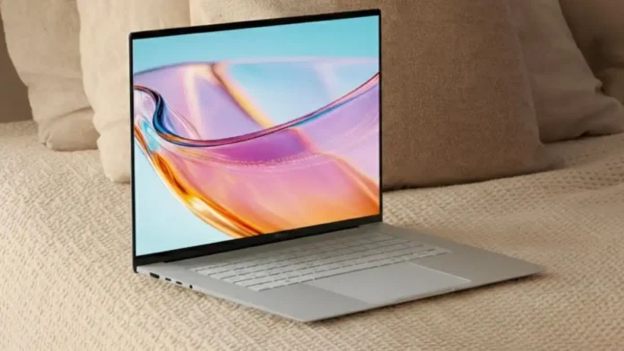 ASUS Zenbook S16 laptop showing its thin bezels, large display, and full-size keyboard on a soft surface