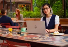 HP EliteBook 6 G2q Launches With Snapdragon X2, OLED Display, and 28-Hour Battery Person using HP EliteBook laptop in an outdoor café environment for work