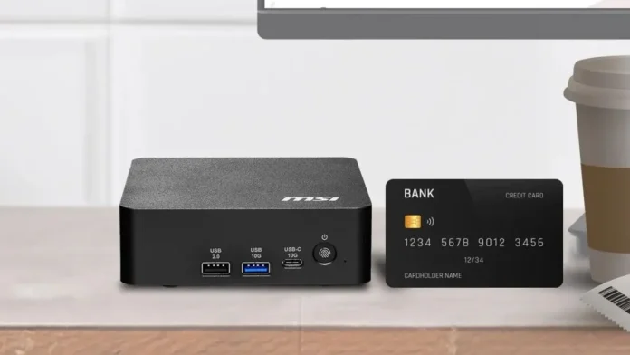 MSI Cubi NUC AI+ 3MG desk size comparison MSI Cubi NUC AI+ 3MG mini PC placed on desk beside bank card showing compact size
